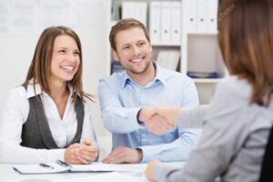 Smiling young man shaking hands with an agent