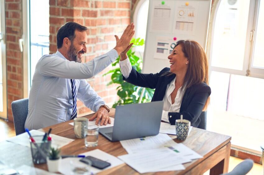 Man and woman are shaking hands in office. Collaborative teamwork.Business professionals